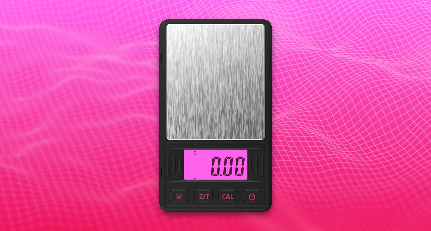 A female hand holds the Pink Truweigh Riot digital pockets scale with the cover showing behind it, the scale is on with the pink backlight visible.